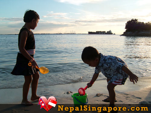 Kids enjoying playing in sand in Sentosa Island Kids enjoying playing in sand in Sentosa Island